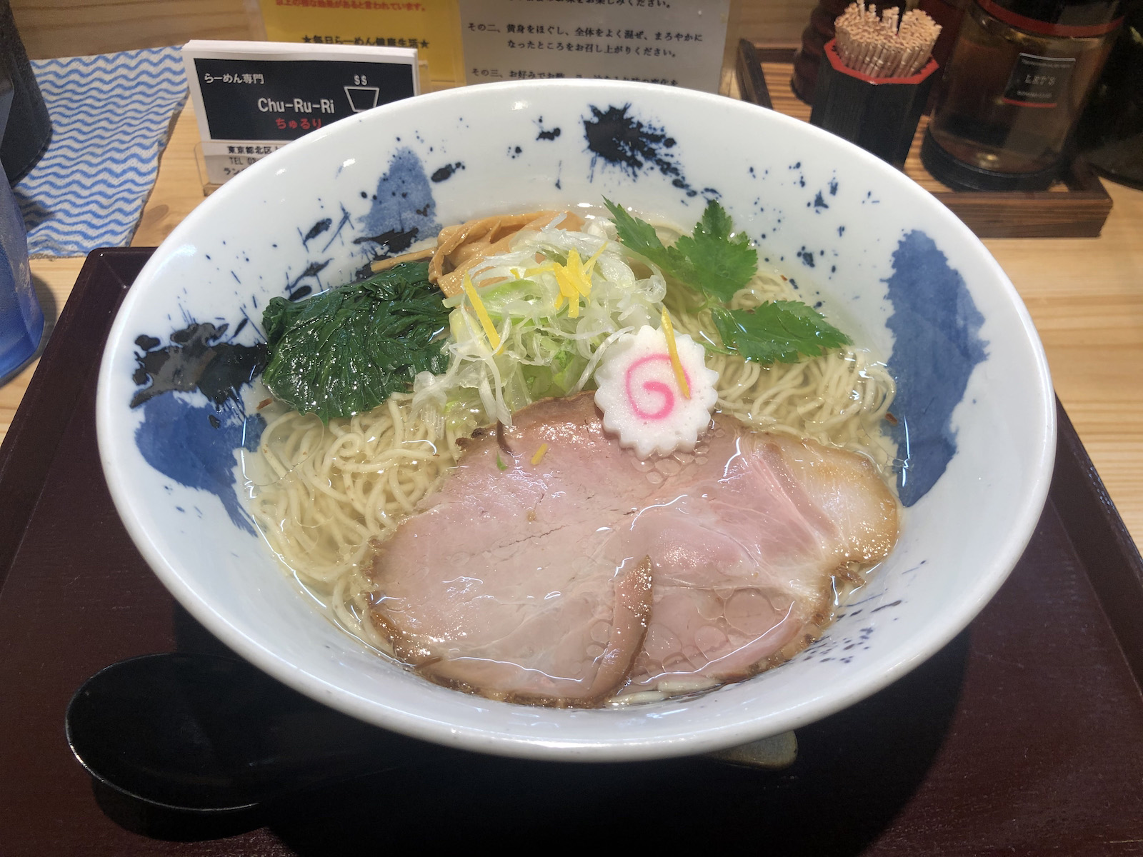 大ぶりのチャーシュー・薄切りの白ねぎと細く切られたゆず皮・ほうれん草・メンマ・三つ葉が乗った、澄んだ色のスープの塩ラーメン